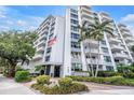 View of the Harbour Hill building exterior showcasing balcony views, trees, and a building entrance at 700 Beach Ne Dr # 602, St Petersburg, FL 33701