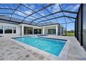 Stunning screened-in pool featuring a covered lounge area and stylish brick patio at 937 Old Welcome Rd, Lithia, FL 33547
