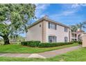 Charming two-story condo with green shutters, manicured landscaping, and a view of the lake at 10330 Carrollwood Ln # 95, Tampa, FL 33618