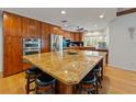 Gourmet kitchen with stainless steel appliances, granite countertops, and a large center island with seating at 10502 Lake Williams Dr, Odessa, FL 33556