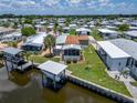Aerial view of waterfront home with boat lift and lush landscaping in a vibrant community at 108 W Saint Annes Cir, Apollo Beach, FL 33572