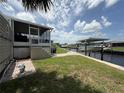 Backyard with a boat lift and lush green grass leading down to the water at 108 W Saint Annes Cir, Apollo Beach, FL 33572