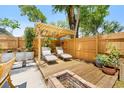 Relaxing backyard retreat with lounge chairs, a pergola, a wooden deck, and a fire pit at 1313 W Carissa Ct, Tampa, FL 33604