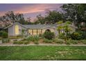 Well-maintained single-story home at dusk featuring manicured landscaping and updated windows at 13310 Golf Crest Cir, Tampa, FL 33618