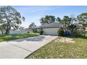 Exterior view of the home showing the driveway, manicured lawn, and fully fenced yard at 13441 Barlington St, Spring Hill, FL 34609