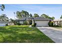 Beautiful home featuring a well-manicured lawn, double door entry, and a two-car garage at 13441 Barlington St, Spring Hill, FL 34609