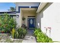 Inviting front porch with beautiful landscaping, and a charming oval window door at 13441 Barlington St, Spring Hill, FL 34609