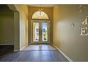 Bright foyer with double doors, tile floor transition, and views to exterior at 1835 Fircrest Ct, Wesley Chapel, FL 33543