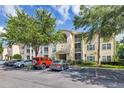 Three-story condo building with balconies, green shrubs, trees, and a parking lot in front at 18439 Bridle Club Dr # 18439, Tampa, FL 33647