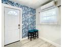 Welcoming entryway features stylish blue wallpaper, modern light fixtures, and vinyl floors at 1887 Springtime Ave, Clearwater, FL 33755
