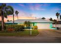Charming single-story home with a two-car garage, lush landscaping, and palm trees, perfect for relaxed coastal living at 2010 E Vina Del Mar Blvd, St Pete Beach, FL 33706
