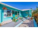 Cozy patio with seating, complemented by vibrant flowers and turquoise accents, offers a relaxing outdoor space at 2010 E Vina Del Mar Blvd, St Pete Beach, FL 33706