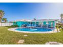 An inviting in-ground swimming pool is surrounded by a brick patio and comfortable seating in the backyard at 2010 E Vina Del Mar Blvd, St Pete Beach, FL 33706
