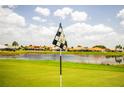 Golf course image showcasing putting green, water feature, and community homes in a desirable neighborhood under sunny skies at 2221 Platinum Dr, Sun City Center, FL 33573