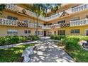 Exterior view of a beautiful condominium building showcasing lush landscaping in a well-maintained courtyard at 2310 Denmark St # 34, Clearwater, FL 33763