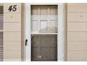 Close-up of unit #45 entrance with screened door and stone facade at 2311 Brisbane St # 45, Clearwater, FL 33763