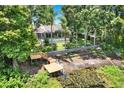 Backyard aerial view featuring a pool, lush greenery, access to a small lake, and a new dock at 2454 Shadecrest Rd, Land O Lakes, FL 34639
