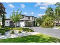 Two-story home featuring a three-car garage, paved driveway, and professionally designed landscaping at 2819 Safe Harbor Dr, Tampa, FL 33618