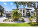 Striking two-story home with lush landscaping, brick driveway, and modern architectural details at 2819 Safe Harbor Dr, Tampa, FL 33618