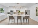 Modern kitchen with island, barstool seating, stainless appliances, and pendant lighting at 3381 19Th Sw Pl, Largo, FL 33774