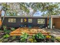 Inviting front yard with cozy deck seating area, complemented by beautiful landscaping and a modern design at 412 Mira Vista Dr, Dunedin, FL 34698