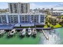 Beautiful waterfront building with boat slips, featuring manicured landscaping, serene views, and modern architecture at 415 Island Way # 507, Clearwater Beach, FL 33767