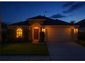 Inviting home exterior at twilight, featuring a two-car garage and manicured lawn at 4510 Beaumaris Dr, Land O Lakes, FL 34638