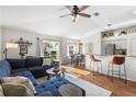 Open-concept living room with a cozy blue sectional and hardwood floors at 4510 Beaumaris Dr, Land O Lakes, FL 34638