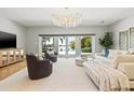 Bright living room with a crystal chandelier and views of the pool and water at 511 Windward Psge, Clearwater Beach, FL 33767