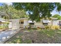 Quaint one-story home featuring awning-shaded windows and a pleasant, established front garden at 516 Northmoor N Ave, St Petersburg, FL 33702