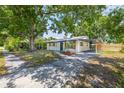 Charming single-story home with a covered parking area and mature trees, offering shade and curb appeal at 6304 S S Grady Ave, Tampa, FL 33616