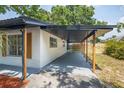 Side exterior showcasing a covered parking area with a wooden privacy fence at 6304 S S Grady Ave, Tampa, FL 33616