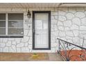 Close-up of the front door, highlighting the stone facade and charming welcome mat at 9011 Hunt Club Ln, Port Richey, FL 34668
