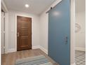 Bright entryway with a wood front door and a stylish blue sliding barn door at 11 Baymont St # 505, Clearwater Beach, FL 33767
