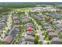 Aerial view of a residential neighborhood featuring an in-ground pool, mature trees and landscaping at 12382 Tibbetts St, Odessa, FL 33556