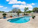 Sparkling pool surrounded by a travertine patio and a white fence, perfect for outdoor enjoyment at 13186 Linden Place Dr, Seminole, FL 33776