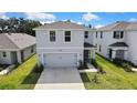 Two-story home with manicured lawn, gray exterior, and convenient two-car garage at 13648 Whiskey Daisy Dr, Dade City, FL 33525