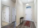 Entryway with front door, hall table, rug, and views into a bathroom with tile floors at 14371 Edinburgh Moor Dr, Wimauma, FL 33598