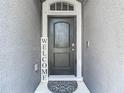 This front entrance features a black door, a welcome sign, and a decorative door mat at 14371 Edinburgh Moor Dr, Wimauma, FL 33598
