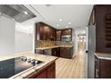 Modern kitchen featuring wood cabinets, stainless steel appliances, granite counters, and a stylish backsplash at 1510 Patricia Ave, Dunedin, FL 34698