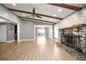 Bright living room with wood beams, fireplace, and laminate floors leading to a dining area at 1510 Patricia Ave, Dunedin, FL 34698