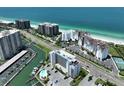 An inviting aerial view of a waterfront condo complex on the beach with well maintained landscaping and community pool at 1591 Gulf Blvd # 304S, Clearwater Beach, FL 33767