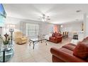 Spacious living room featuring tile floors, ceiling fan, and views into dining area at 17509 Queensland St, Land O Lakes, FL 34638