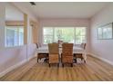 Sunlit dining room featuring wood floors, woven chairs, and a large window view at 2228 Hannah S Way, Dunedin, FL 34698