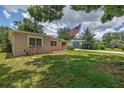 View of the home from under a large tree with American flag in the front yard at 2415 York N St, St Petersburg, FL 33710