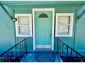 A detailed view of a light-teal door framed by white trim and matching windows for a welcoming entrance at 3110 10Th N Ave, St Petersburg, FL 33713