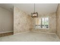 Living room featuring textured walls, neutral carpet, plantation shutters, and modern lighting at 3262 Westcott Ct, Palm Harbor, FL 34684