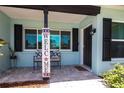 Charming front porch with a welcoming bench and patriotic decor, enhancing curb appeal at 3312 Kenmore Dr, Sarasota, FL 34231