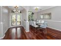 Bright dining room with white and blue chairs, dark hardwood flooring, and a doorway to the entry at 335 Palmdale Dr, Oldsmar, FL 34677