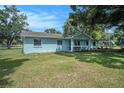 Quaint light blue home with a well-manicured lawn and side yard at 3440 Pittman Rd, Dover, FL 33527